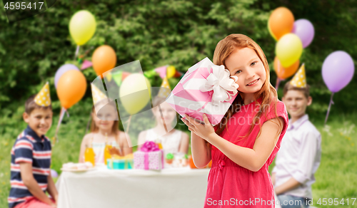 Image of lovely red haired girl with birthday gift at party