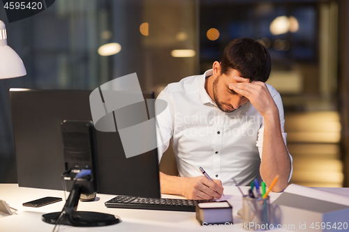 Image of businessman with computer working at night office