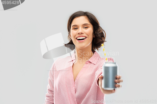 Image of woman drinking soda from can with paper straw