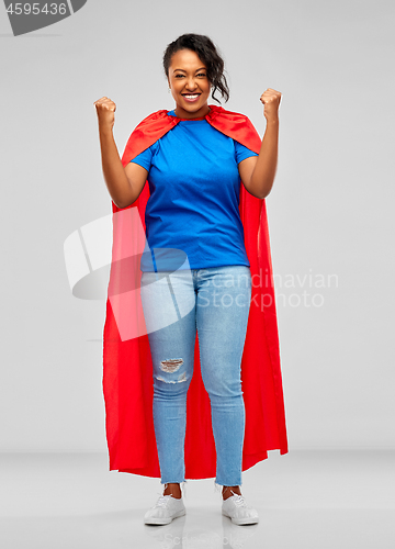 Image of happy african american woman in superhero red cape