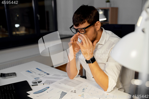 Image of tired businessman working at night office