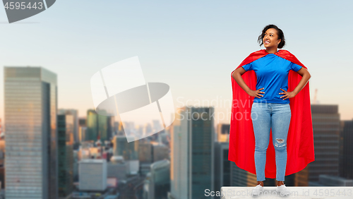 Image of happy african american woman in superhero red cape