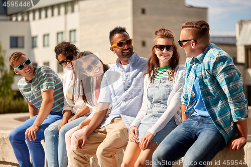 Image of happy friends in sunglasses at city in summer