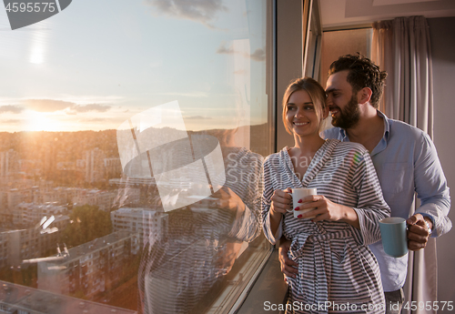 Image of young couple enjoying evening coffee by the window