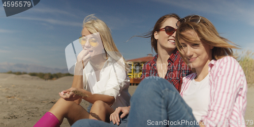 Image of Group of girlfriends having fun on beach during autumn day