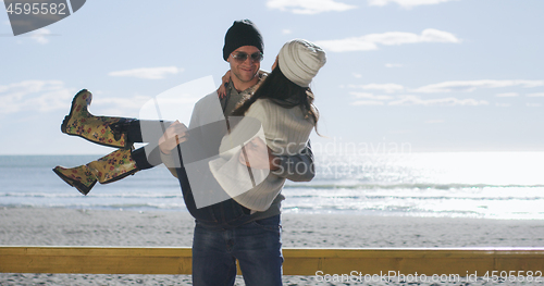 Image of Couple having fun on beautiful autumn day at beach