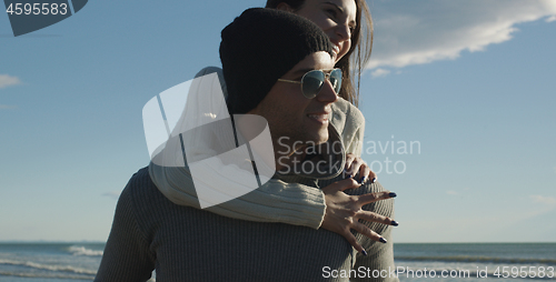 Image of couple having fun at beach during autumn