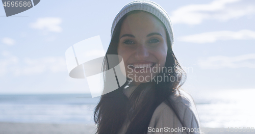 Image of Girl In Autumn Clothes Smiling on beach