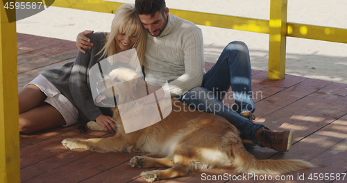 Image of Couple with dog enjoying time on beach