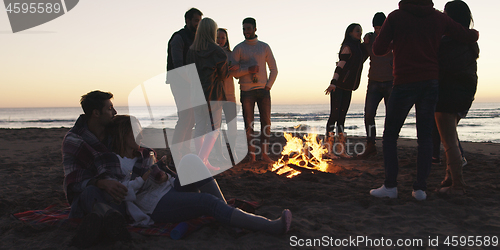 Image of Friends having fun at beach on autumn day