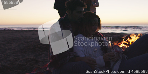 Image of Friends having fun at beach on autumn day