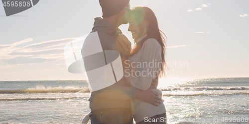 Image of Couple having fun on beautiful autumn day at beach