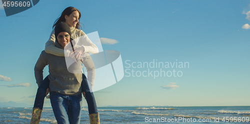 Image of couple having fun at beach during autumn