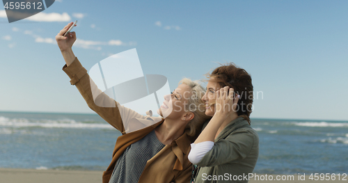 Image of Girls having time and taking selfie on a beach