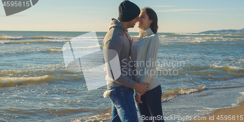 Image of Couple having fun on beautiful autumn day at beach