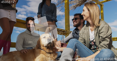 Image of Group of friends having fun on autumn day at beach