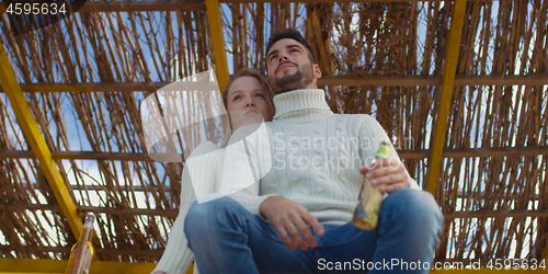 Image of Couple drinking beer together at the beach