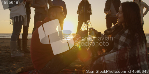 Image of Friends having fun at beach on autumn day