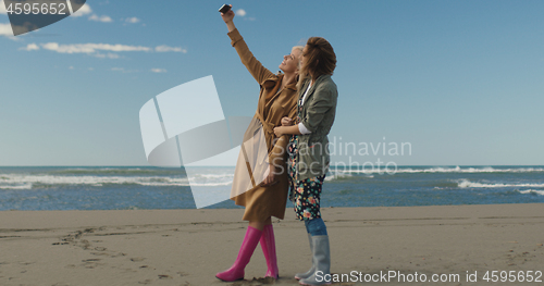 Image of Girls having time and taking selfie on a beach