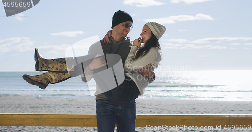 Image of Couple having fun on beautiful autumn day at beach