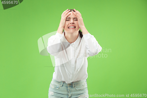 Image of Beautiful woman looking suprised and bewildered isolated on green
