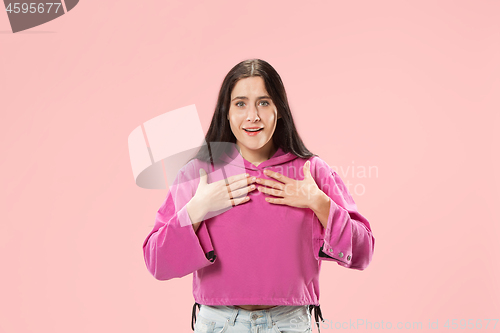 Image of The happy business woman standing and smiling against pink background.