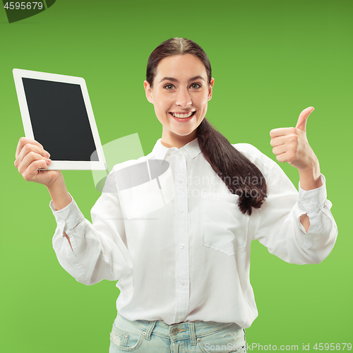 Image of Portrait of a confident casual girl showing blank screen of laptop isolated over green background