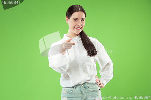 Image of The happy business woman point you and want you, half length closeup portrait on green background.