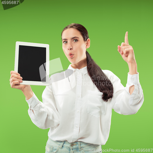 Image of Portrait of a confident casual girl showing blank screen of laptop isolated over green background