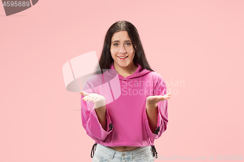 Image of The happy business woman standing and smiling against pink background.
