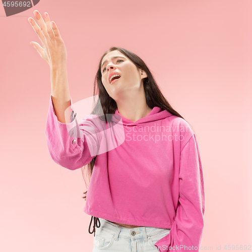 Image of Beautiful woman looking suprised and bewildered isolated on pink