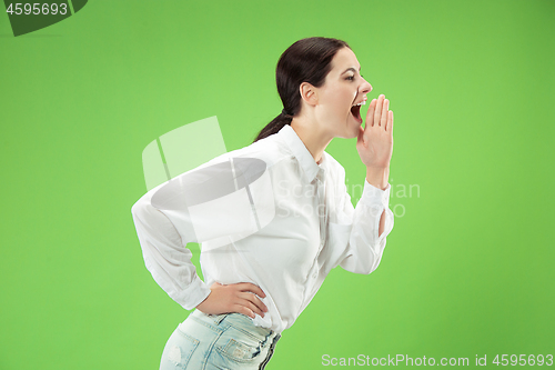 Image of Isolated on green young casual woman shouting at studio