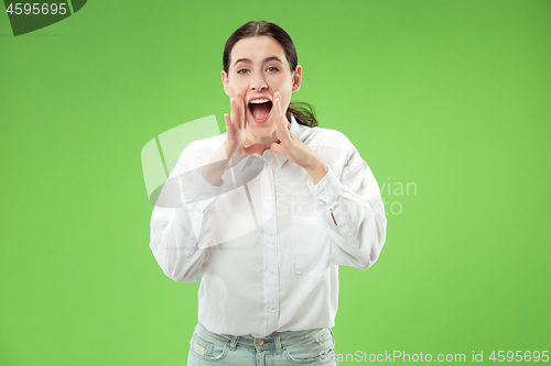 Image of Isolated on green young casual woman shouting at studio