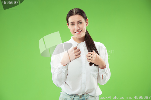 Image of The happy business woman standing and smiling against green background.
