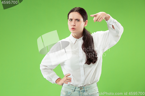 Image of The overbearing business woman point you and want you, half length closeup portrait on green background.