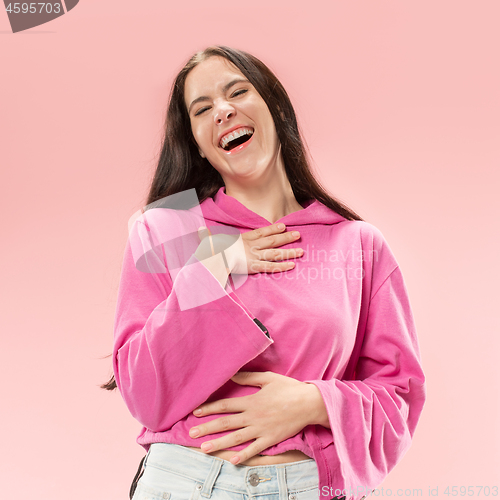 Image of The happy business woman standing and smiling against pink background.
