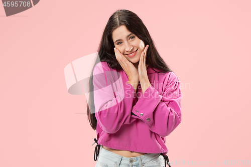 Image of The happy business woman standing and smiling against pink background.