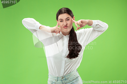 Image of The squint eyed woman with weird expression isolated on green