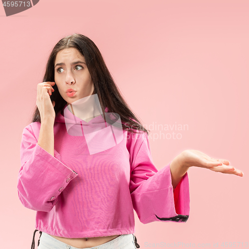 Image of Young beautiful woman using mobile phone studio on pink color background