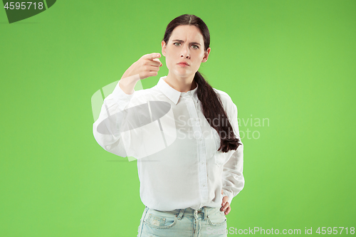Image of The overbearing business woman point you and want you, half length closeup portrait on green background.