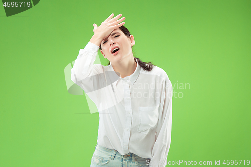 Image of Beautiful woman looking suprised and bewildered isolated on green