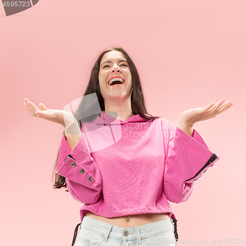 Image of The happy business woman standing and smiling against pink background.