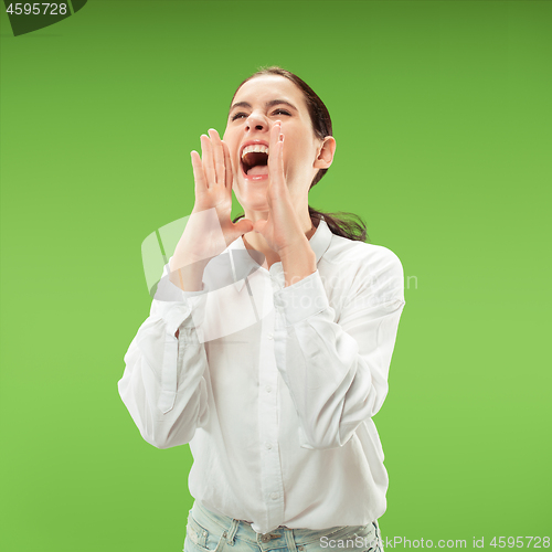 Image of Isolated on green young casual woman shouting at studio