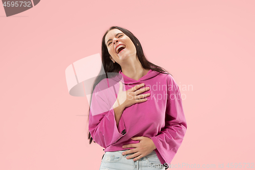 Image of The happy business woman standing and smiling against pink background.