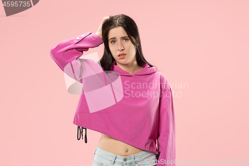 Image of Beautiful woman looking suprised and bewildered isolated on pink