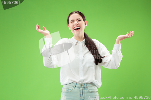 Image of The happy business woman standing and smiling against green background.