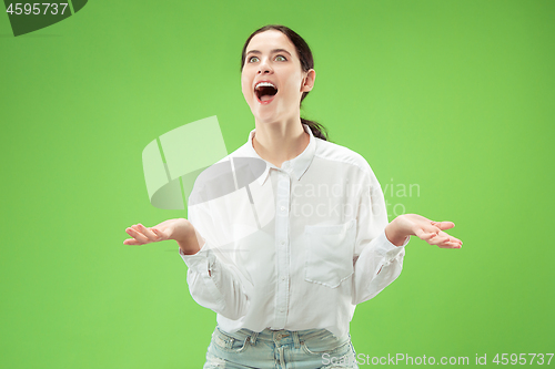 Image of Beautiful woman looking suprised isolated on green