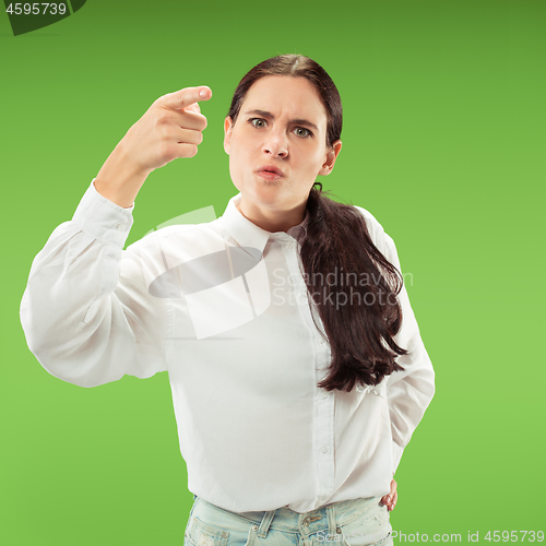 Image of Beautiful female half-length portrait isolated on green studio backgroud. The young emotional surprised woman