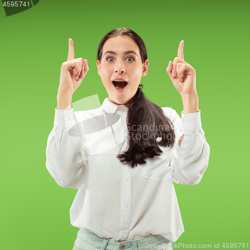 Image of Beautiful woman looking suprised isolated on green