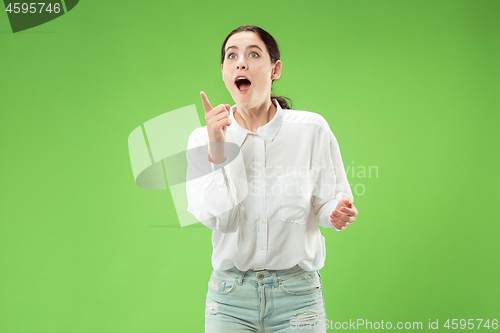 Image of Beautiful woman looking suprised isolated on green